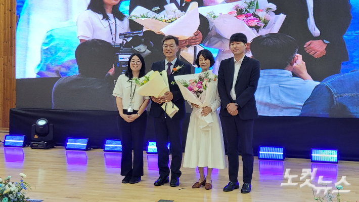시청 직원들이 전달한 꽃다발을 안고 배우자와 함께 기념사진을 찍고 있는 김중남 강릉시장. 전영래 기자