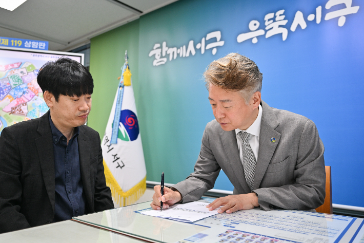 김이강 전남광주특별시 서구청장이 1일 1호 결재로 '선한영향력 시민회의 100' 구성에 서명했다. 광주 서구 제공