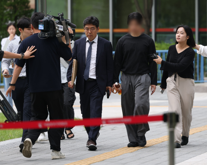 잠실 개표소 봉쇄 시위 첫날 경찰관을 폭행한 혐의를 받는 20대 남성이 2일 서울 송파구 동부지법에서 열린 영장실질심사에 출석하기 위해 법정으로 향하고 있다. 연합뉴스