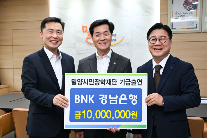 BNK경남은행 허종구 부행장(사진 오른쪽)이 (재)밀양시민장학재단 안병구 이사장(가운데)에게 장학기금 1천만원을 전달하고 있다. 밀양시 제공