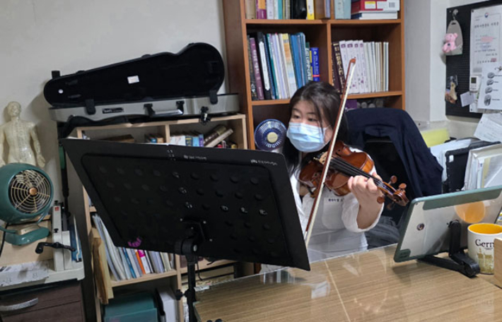 IBK TOGETHER 오케스트라 단원으로 선발된 그린한의원 원장 장그린(47)씨가 진료가 끝난 뒤 원장실에서 바이올린을 연습하고 있다. 장그린씨 제공