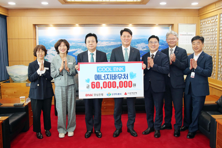 BNK경남은행 김태한 은행장(사진 오른쪽 네번째)이 창원시 강기윤 시장에게 6천만원 상당의 에너지바우처를 전달하고 있다. 창원시 제공 