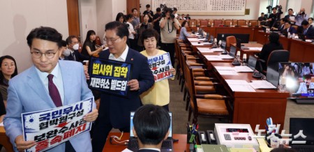 8일 서울 여의도 국회 법제사법위원회 전체회의에서 국민의힘 의원들이 피켓을 들고 항의 한뒤 퇴장하고 있다.