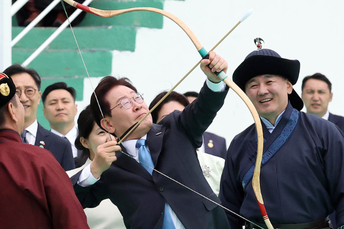 몽골을 국빈방문 중인 이재명 대통령이 11일(현지시간) 울란바타르 나담축제장에서 전통 활을 쏘고 있다. 오른쪽은 오흐나 후렐수흐 몽골 대통령. 연합뉴스
