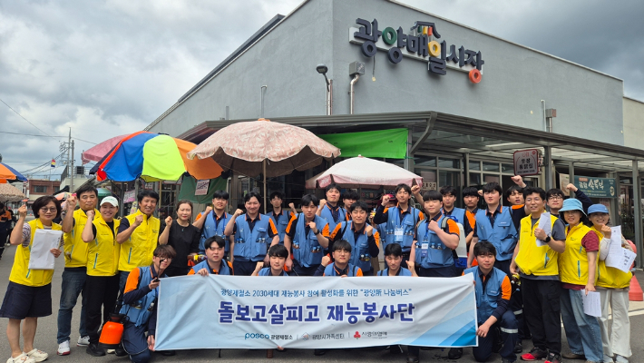 포스코 광양제철소 신입사원들이 나눔버스 행사의 하나로 전통시장 방역을 마친 뒤 기념촬영을 하고 있다. 광양제철소 제공
