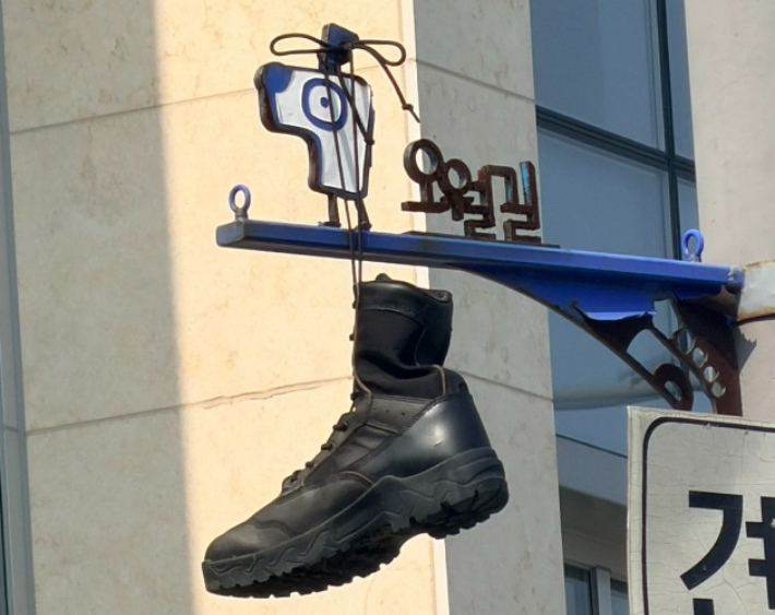 지난달 30일 오전 광주 동구 옛 시외버스터미널 부지 오월길 안내판에 군화가 걸려 있다. 독자 제공