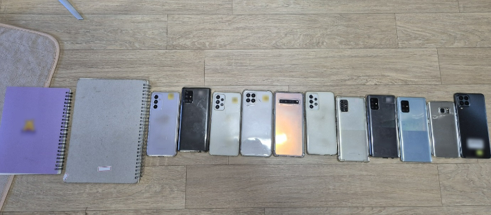계좌 모집책들이 보관하고 있던 장부와 휴대전화. 부산경찰청 제공 