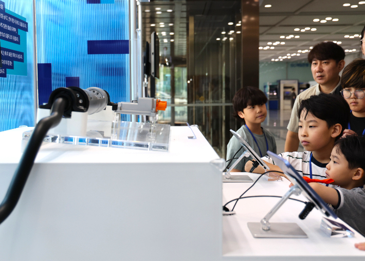 지난 25일 경기도 의왕시 현대위아 의왕연구소에서 열린 '오픈 랩(Open LAB)' 행사에 참여한 임직원과 가족들이 현대위아의 ARS(Active Roll Stabilization) 전시품을 살펴보는 모습. 현대위아 제공