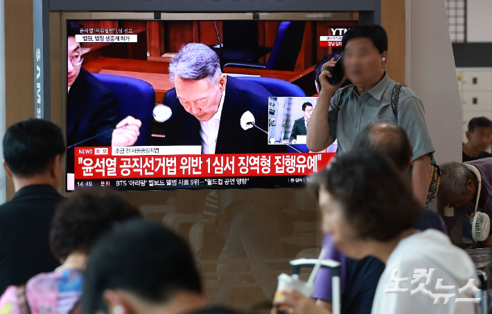 27일 서울 용산구 서울역 대합실에서 시민들이 윤석열 전 대통령의 공직선거법 위반 혐의 1심 선고 생중계를 보고 있다. 이날 법원은 윤석열에게 징역 1년 6개월에 집행유예 3년을 선고했다. 류영주 기자