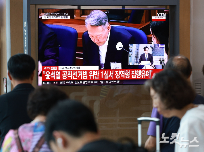 27일 서울 용산구 서울역 대합실에서 시민들이 윤석열 전 대통령의 공직선거법 위반 혐의 1심 선고 생중계를 보고 있다. 이날 법원은 윤석열에게 징역 1년 6개월에 집행유예 3년을 선고했다. 류영주 기자