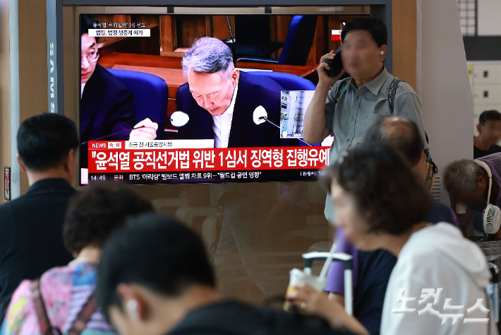 27일 서울 용산구 서울역 대합실에서 시민들이 윤석열 전 대통령의 공직선거법 위반 혐의 1심 선고 생중계를 보고 있다. 이날 법원은 윤석열에게 징역 1년 6개월에 집행유예 3년을 선고했다. 류영주 기자