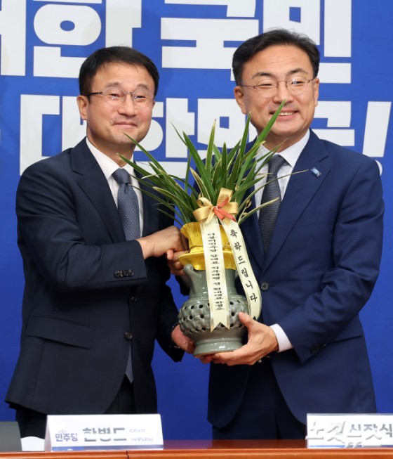 더불어민주당 한병도 당대표 직무대행 겸 원내대표가 28일 서울 여의도 국회에서 취임 인사차 방문한 조국혁신당 신장식 대표에게 축하 난을 전달하고 있다.