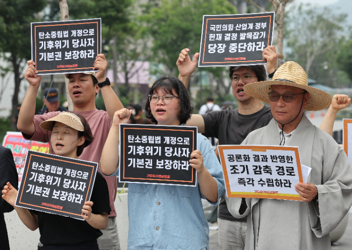 지난 16일 서울 광화문광장에서 기후위기비상행동이 연 헌재결정 이행과 탄소중립법 개정을 위한 제헌절 기자회견에서 참가자들이 과학적 사실과 국제적 기준에 근거한 장기감축경로를 법률로 마련할 것을 촉구하는 구호를 외치고 있다. 연합뉴스