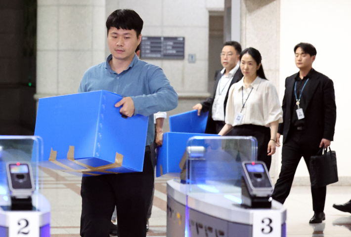 지난 23일 압수수색을 마친 합동수사본부 관계자들이 과천 중앙선거관리위원회에서 나오고 있다. 연합뉴스