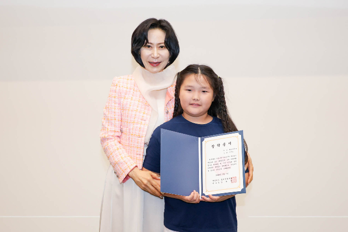 롯데장학재단 장혜선 이사장이 7일 서울 중구 서소문성지 역사박물관에서 '2026년 신격호 롯데 나라사랑 장학금(직업군인) 전달식'에서 박시은 장학생에게 장학증서를 수여하고 기념사진을 찍고 있다. 롯데장학재단 제공