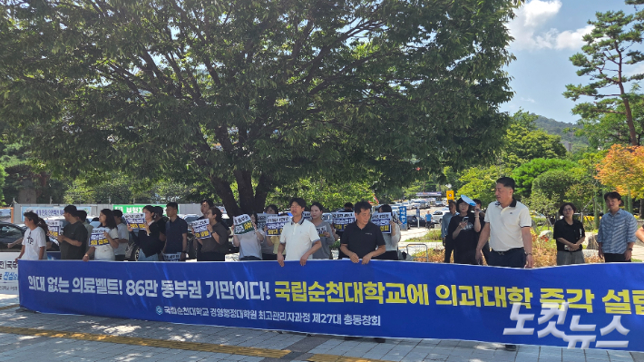  6일 김민석 더불어민주당 당대표 후보의 강연이 열린 순천대학교 우석홀 앞에서 순천대 총동창회와 범시민추진위원회 관계자 등이 국립순천대학교 의과대학 유치를 촉구하는 현수막을 들고 있다.  박사라 기자 
