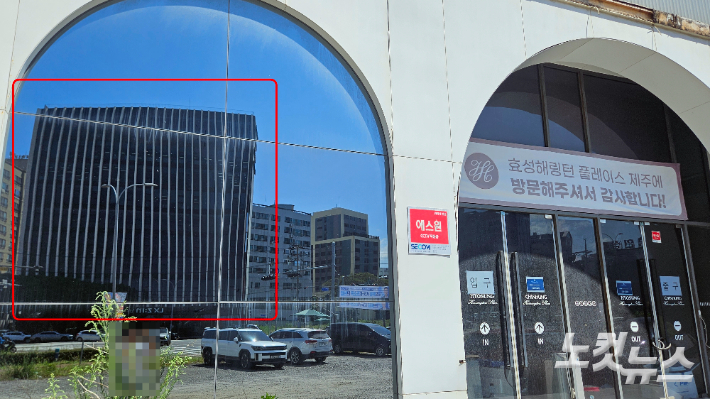 모델하우스 거울에 비친 빨간색 표시 건물 자리에 오 전 지사 선거사무소가 있었다. 고상현 기자