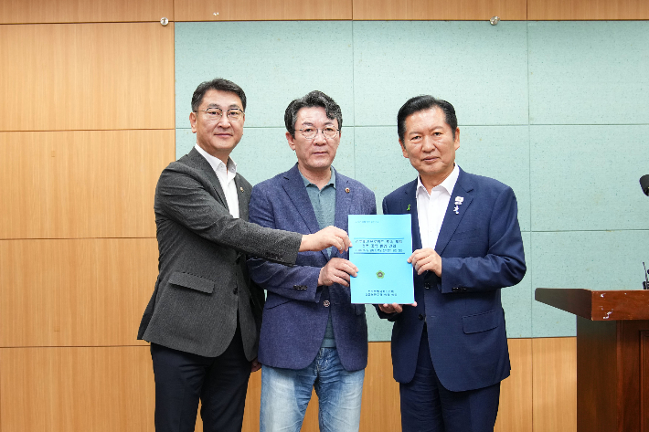전북도의회 민주당 김창현 원내부대표와 정종복 원내대표, 정청래 당대표 후보(왼쪽부터)가 10일 도의회에서 정부 메가프로젝트 후속 계획에 전북 반영을 촉구하는 건의문을 들고 있다. 전북도의회 제공