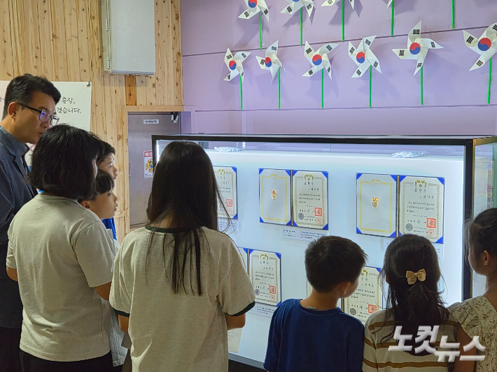 대흥초등학교의 윤민기 교장과 재학생들이 독립유공자 선배들의 표창증서와 훈장을 살펴보고 있다. 김정남 기자