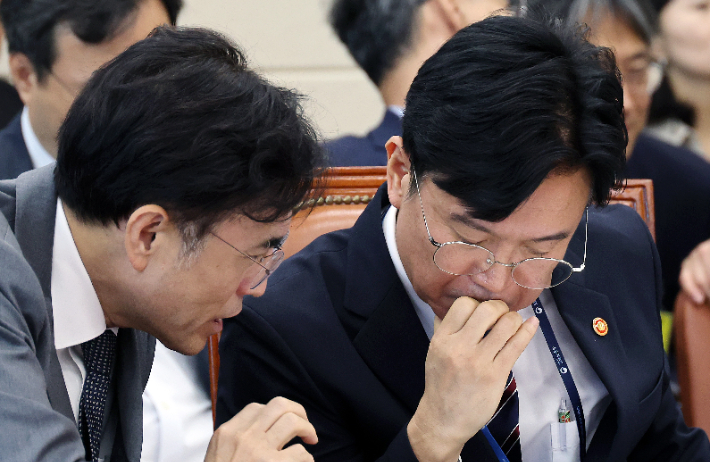 김영훈 고용노동부 장관과 권창준 차관이 12일 국회 기후에너지환경노동위원회 전체회의에서 대화하고 있다. 연합뉴스
