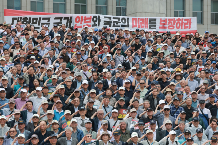 8일 국회 본청 앞 계단에서 국민의힘 한기호·임종득 의원이 육·해·공군사관학교 총동창회, 육사 사관생도 학부모 모임과 함께 연 육·해·공군사관학교 통폐합 및 육군사관학교 지방 이전 반대 총궐기 대회에서 참석자들이 국기에 경례하고 있다. 연합뉴스