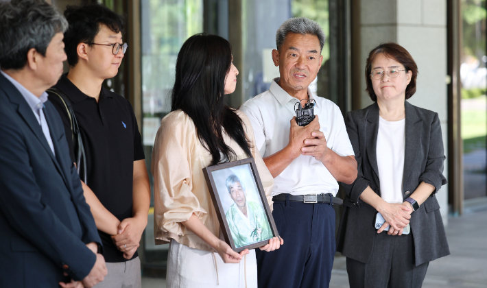 일본제철 강제동원 피해자 고 민문식 씨의 장남 민병조(오른쪽 두번째) 씨와 손녀 민사라 씨가 12일 서울 서초구 대법원에서 열린 일본제철 강제동원 손해배상 청구소송 상고심 선고를 마치고 나와 입장을 밝히고 있다. 연합뉴스