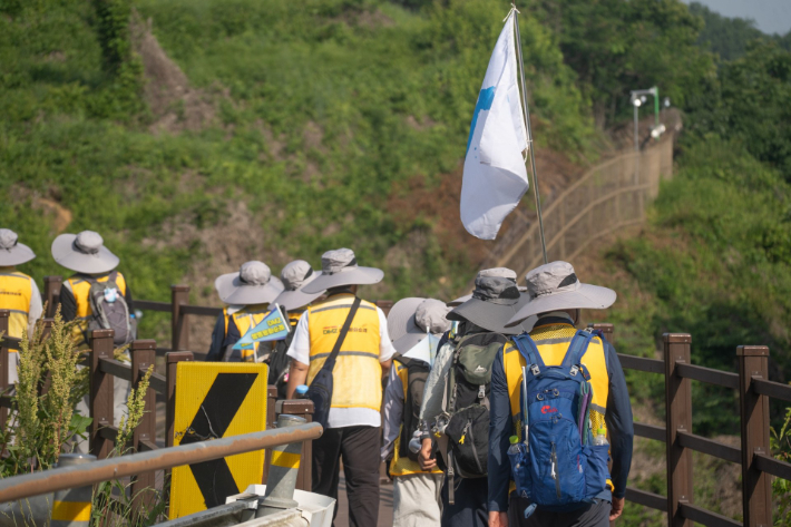 지난해 'DMZ 생명평화순례'에 참가한 종교인들이 한반도기를 들고 접경 지역을 걷고 있다. DMZ 생명평화순례 제공