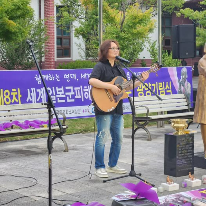 위안부 피해자 기림식에서 기타를 연주하고 있다. 독자제공