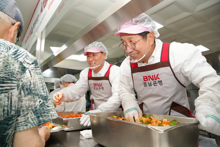 BNK경남은행 김태한 은행장(사진 왼쪽)과 정영두 김해시장(사진 오른쪽)이 배식 봉사를 하고 있다. BNK경남은행 제공 