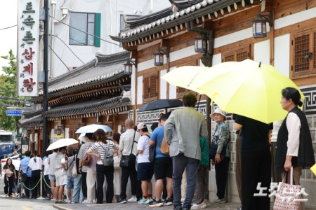 말복인 14일 서울 종로구 토속촌삼계탕에서 시민들과 관광객들이 삼계탕을 먹기 위해 줄을 서고 있다.