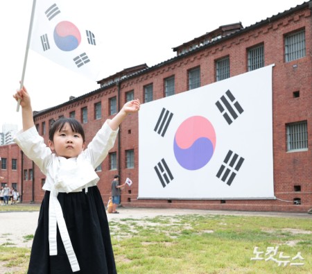 제81주년 광복절인 15일 오전 서울 서대문구 서대문형무소 대형 태극기 앞에서 한 어린이가 태극기를 힘차게 흔들고 있다.