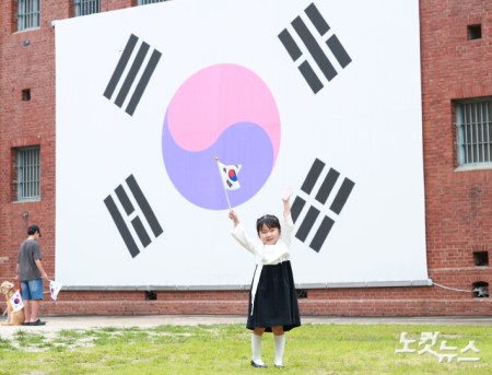 제81주년 광복절인 15일 오전 서울 서대문구 서대문형무소 대형 태극기 앞에서 한 어린이가 태극기를 힘차게 흔들고 있다.