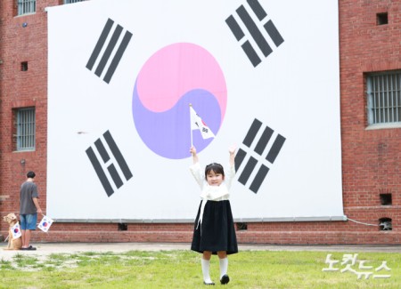 제81주년 광복절인 15일 오전 서울 서대문구 서대문형무소 대형 태극기 앞에서 한 어린이가 태극기를 힘차게 흔들고 있다.