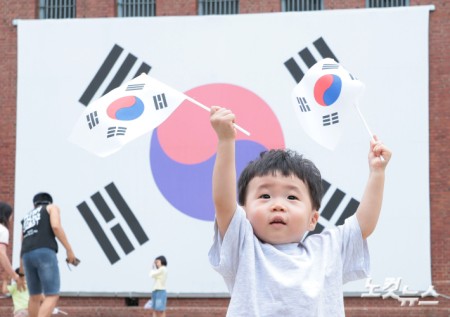 제81주년 광복절인 15일 오전 서울 서대문구 서대문형무소 대형 태극기 앞에서 한 어린이가 태극기를 힘차게 흔들고 있다.