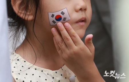 제81주년 광복절인 15일 오전 서울 서대문구 서대문형무소에서 한 아이가 얼굴에 태극기 스티커를 붙이고 있다.