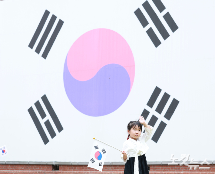 제81주년 광복절인 15일 오전 서울 서대문구 서대문형무소 대형 태극기 앞에서 한 어린이가 태극기를 힘차게 흔들고 있다. 류영주 기자