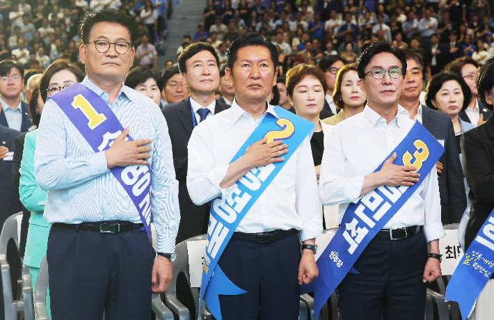  더불어민주당 송영길, 정청래, 김민석 당 대표 후보가 16일 경기도 수원시 수원종합운동장 실내체육관에서 열린 '민주당 당 대표ㆍ최고위원 후보자 경기 합동연설회'에서 국기에 경례하고 있다. 연합뉴스