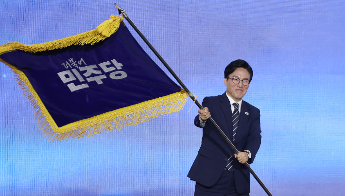 더불어민주당 김민석 신임 당 대표가 17일 대전 컨벤션센터에서 열린 제3회 더불어민주당 정기 전국당원대회에서 당 대표로 선출된 뒤 당기를 흔들어 보이고 있다. 연합뉴스