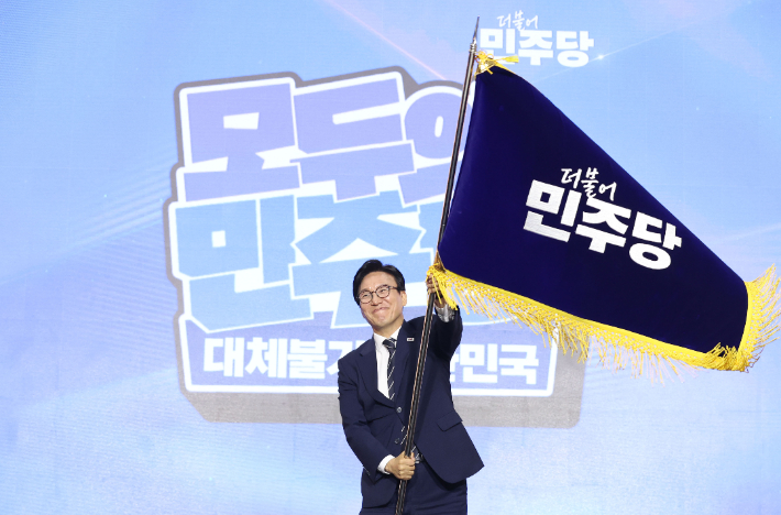 더불어민주당 김민석 신임 당 대표가 17일 대전 컨벤션센터에서 열린 제3회 더불어민주당 정기 전국당원대회에서 당 대표로 선출된 뒤 당기를 흔들어 보이고 있다. 연합뉴스