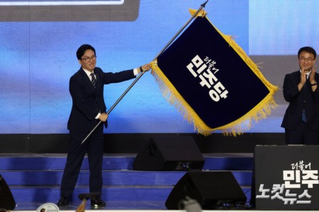 17일 대전 유성구 대전컨벤션센터 제2전시장에서 열린 더불어민주당 제3차 정기전국당원대회에서 선출된 김민석 당대표가 당기를 흔들고 있다.