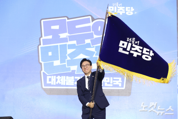 17일 대전 유성구 대전컨벤션센터 제2전시장에서 열린 더불어민주당 제3차 정기전국당원대회에서 선출된 김민석 당대표가 당기를 흔들고 있다. 윤창원 기자