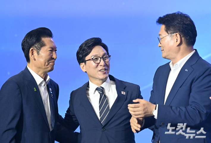 17일 대전 유성구 대전컨벤션센터 제2전시장에서 열린 더불어민주당 제3차 정기전국당원대회에서 선출된 김민석 당대표가 함께 경선을 벌인 정청래 송영길 후보와 포옹을 하고 있다. 윤창원 기자