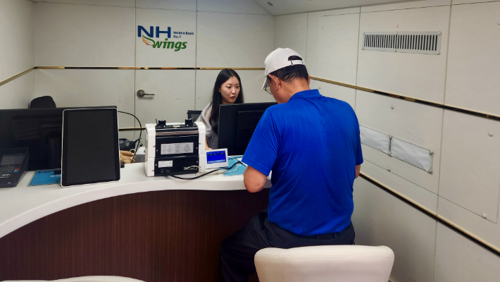 거제시 관내에 설치된 NH농협은행 이동점포에서 지역주민이 금융거래를 하고 있다. NH농협은행 경남본부 제공 