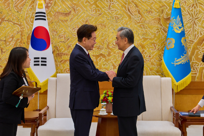 이재명 대통령이 20일 청와대에서 왕이 중국공산당 중앙외사판공실 주임 겸 외교부장과 접견에 앞서 악수하고 있다. 연합뉴스