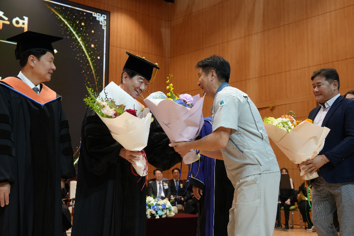 SNT다이내믹스와 SNT에너지 노조 지회장이 최평규 회장에게 축하 꽃다발을 전달하고 있다. SNT그룹 제공