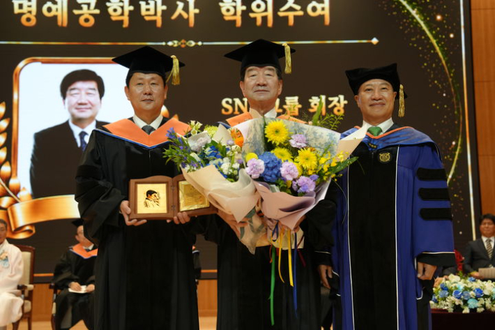 최평규 SNT그룹 회장(사진 오른쪽)과 박민원 국립창원대학교 총장(사진 왼쪽)이 명예공학박사 학위 수여 후 기념촬영을 하고 있다. SNT그룹 제공