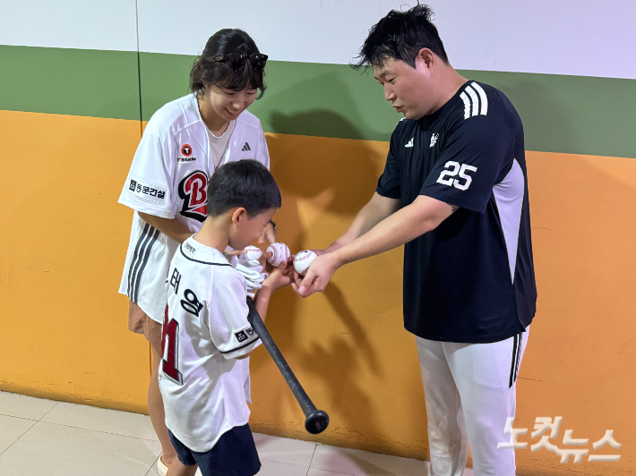 300호 홈런공을 돌려준 팬에게 감사 인사와 함께 선물을 전달하는 양의지(오른쪽). 김조휘 기자