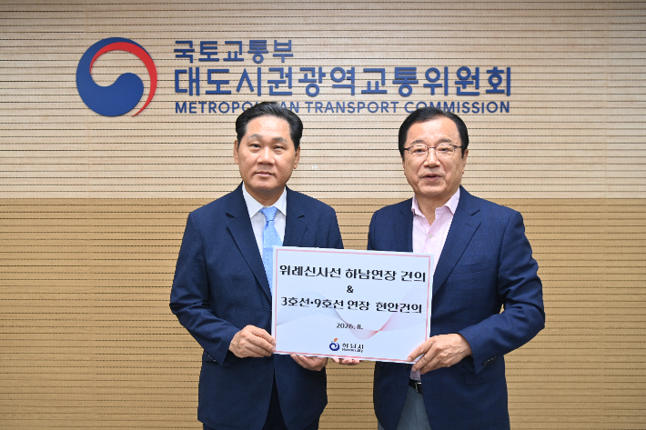 이현재 하남시장(왼쪽)이 김용석 대도시권광역교통위원회 위원장에게 위례신사선 하남 연장 건의서를 전달하고 있다. 하남시 제공