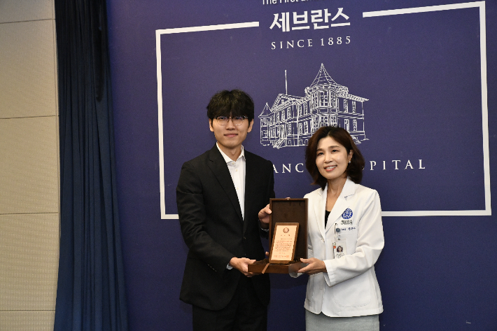 세브란스 어린이병원 천근아 원장이 신지서 9단(사진 왼쪽)에게 감사패를 전달한 후 함께 기념촬영을 하고있다. 한국기원 제공 