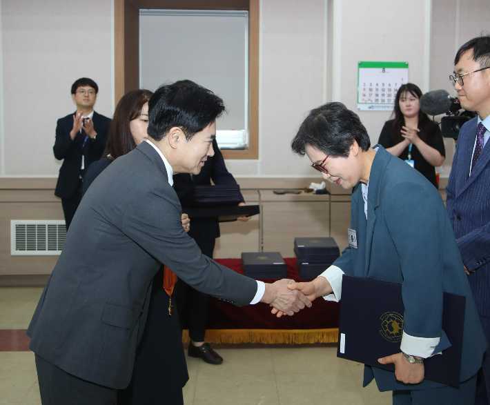 김대중 교육감(왼쪽)이 정부포상 전수식에서 퇴직교원과 악수하고 있다. 통합특별시교육청 제공